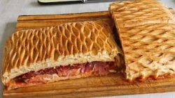 Hornazo, a traditional empanada filled with sausages, perfect for sharing at celebrations.